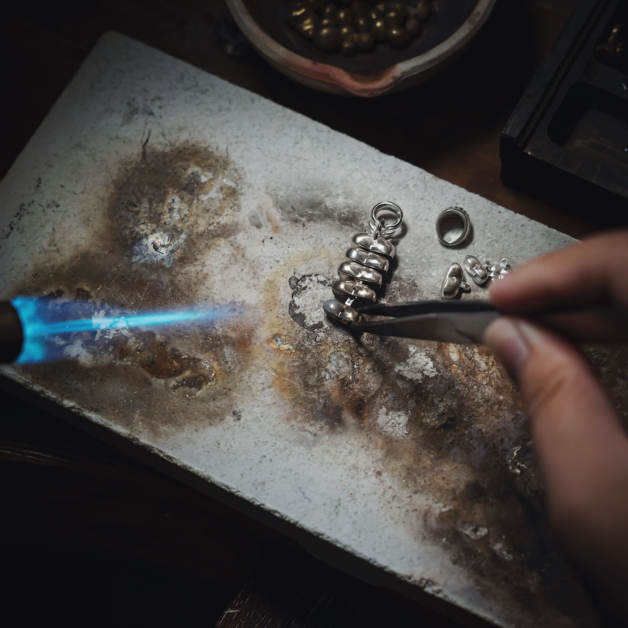 jeweller soldering a silver pendant