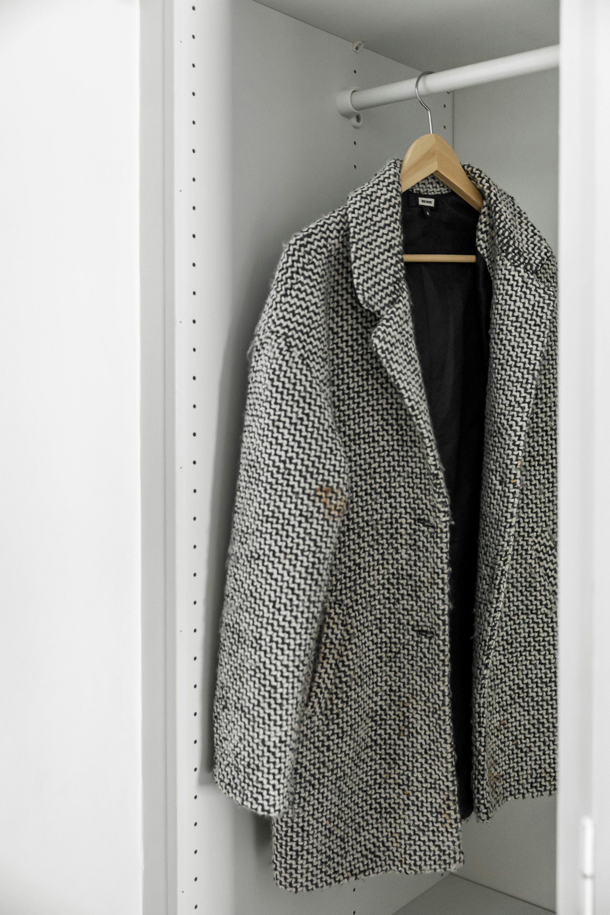 textured wool coat on a wooden hanger