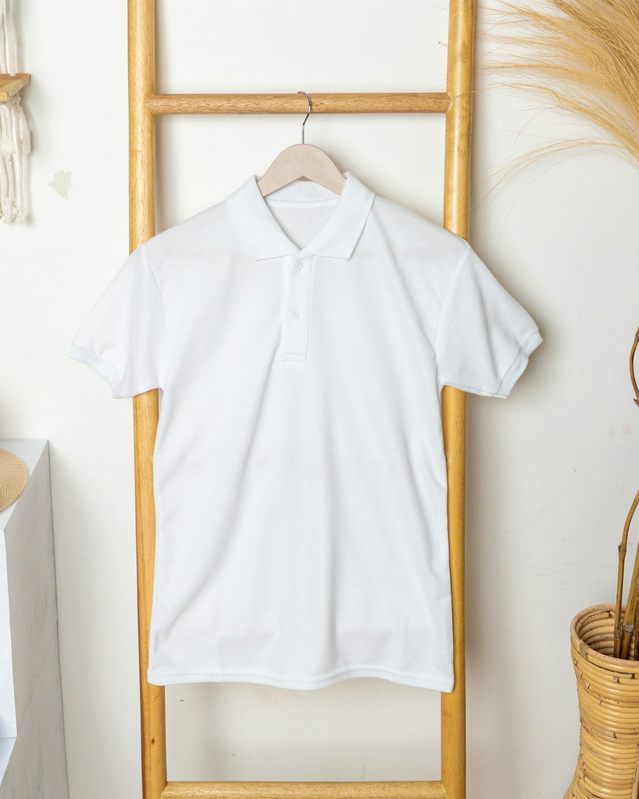 white polo shirt on a wooden hanger